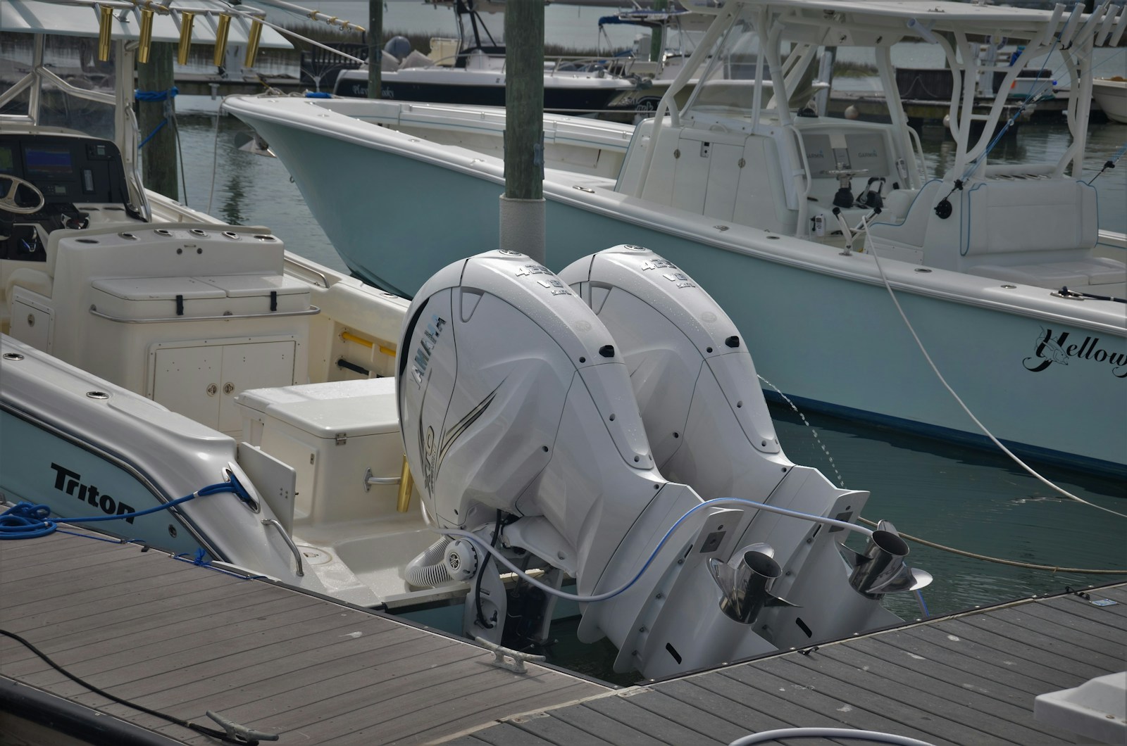 Stock photo of center-console fishing boats at a marina, with twin white outboard motors