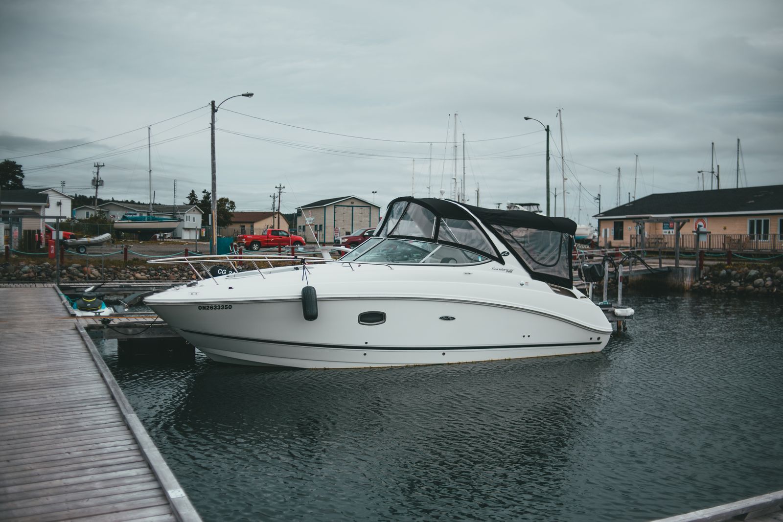 Stock photo of a white recreational cabin cruiser moored beside a marina dock